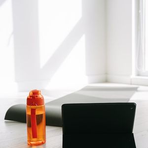 Close-up of a yoga mat and a water bottle in a calm setting.
